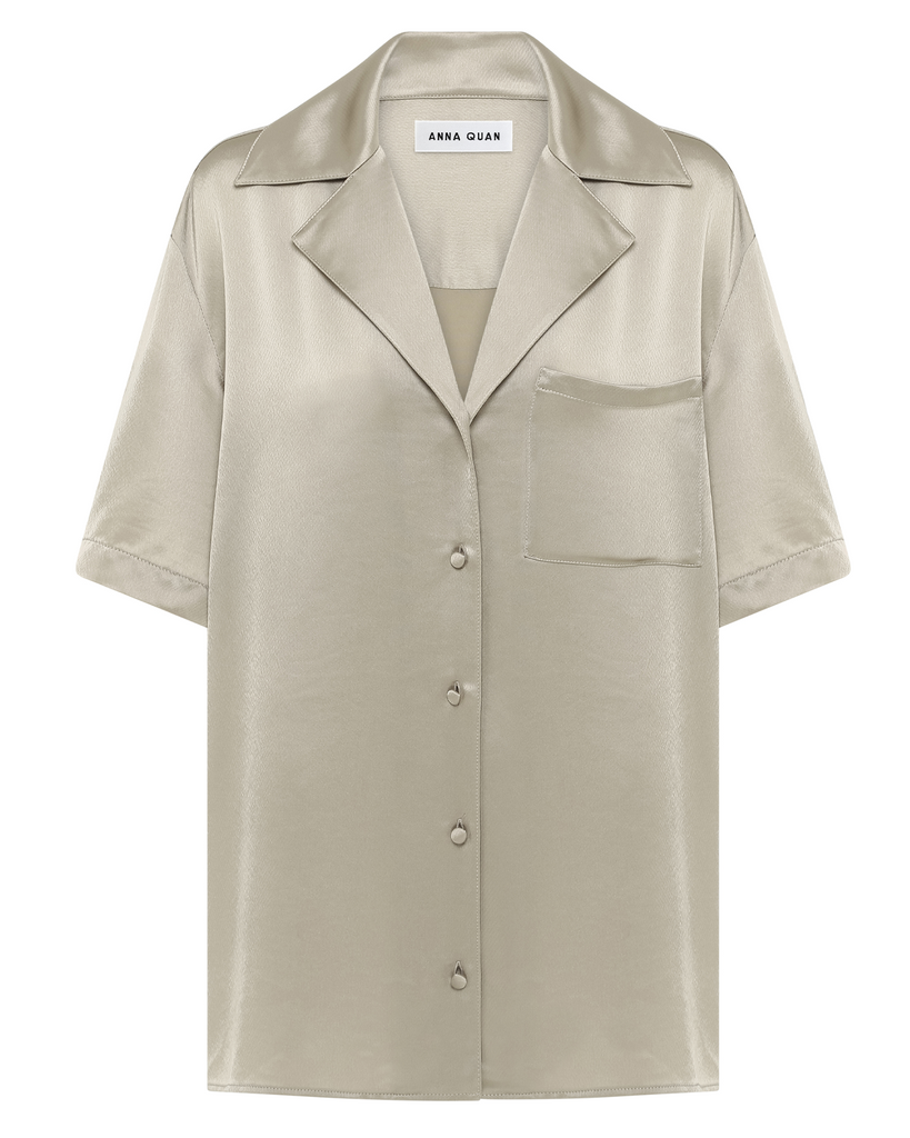 A relaxed unisex fit allowing creativity to style any way you choose. This fluid shirt is cut in a Japanese satin acetate made special with its soft drape and muted taupe hue. Designed with a boxy shoulder, camper collar, breast pocket, and back y By Anna Quan, now available at After Eight. 
