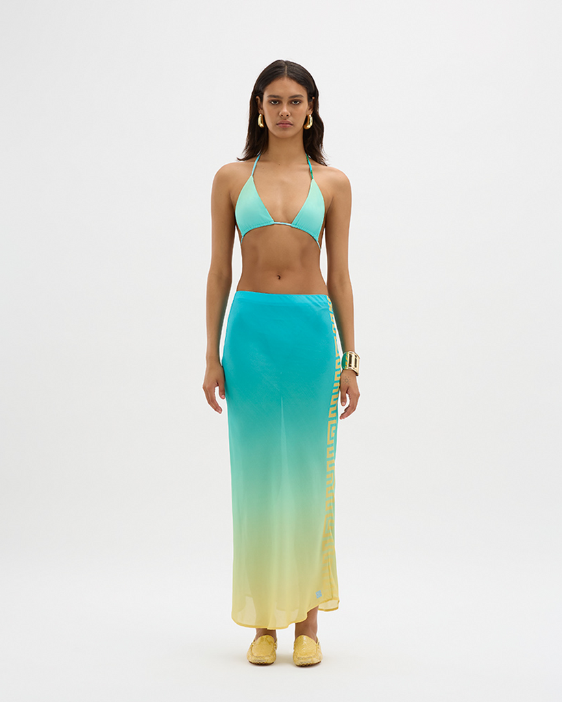 Expertly crafted in a silky vegan cupro blend, this bias-cut maxi skirt is ruched at the back and flows down an elongated hemline to the ankles, creating a timeless silhouette. The signature Muma panel along one side punctuates the gradient with asymmetrical structure, creating a nostalgic and luxurious feel. Simultaneously elegant and relaxed, the high-rise, thick-band elastication around the waist allows for movement, festivity, and indulgence all around. By Muma World, now available at After Eight. 