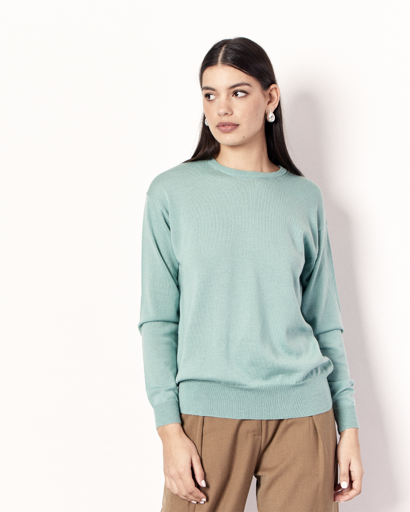 The Crew Neck Sweater is an everyday lightweight knit, featuring ribbed collar, cuff and hem detailing. It is crafted from 100% Extra Fine Merino Wool in a light Green hue. By Romy, now available at After Eight. 