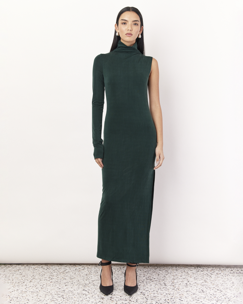 The One Sleeve Maxi Dress takes a twist on classic elegance, featuring one exposed arm and a funnel neck. It is crafted from a soft Oeko-Tex® Certified Bamboo Spandex Jersey and is double lined, perfect to hug you in, in a deep Emerald Green hue. By Romy, now available at After Eight. 