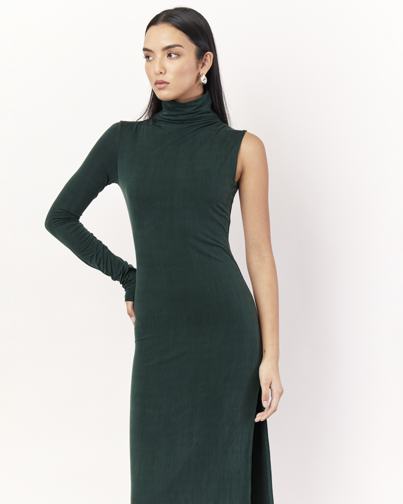 The One Sleeve Maxi Dress takes a twist on classic elegance, featuring one exposed arm and a funnel neck. It is crafted from a soft Oeko-Tex® Certified Bamboo Spandex Jersey and is double lined, perfect to hug you in, in a deep Emerald Green hue. By Romy, now available at After Eight. 