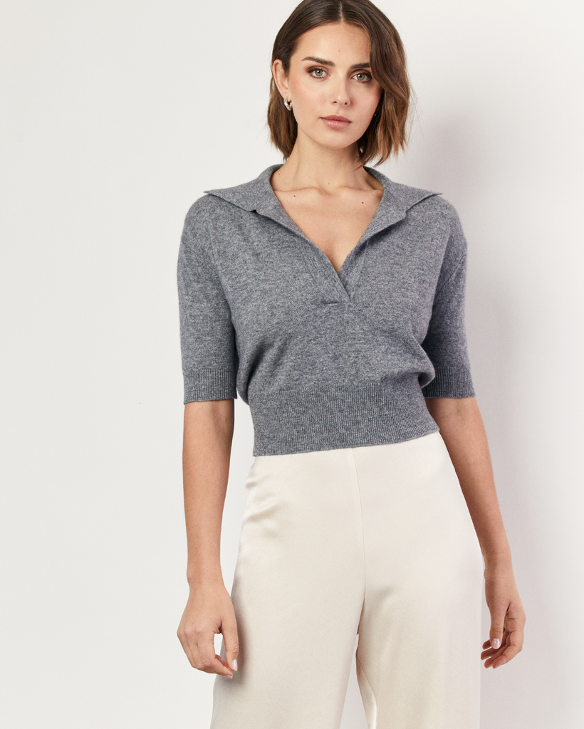 The Collared Short Sleeve Sweater is an interpretation of Romy's signature knitwear silhouettes. Sumptuous and soft, the grey Cashmere blend sweater is crafted with a v-neck collar and flattering a cropped hem. By Romy, now available at After Eight. 