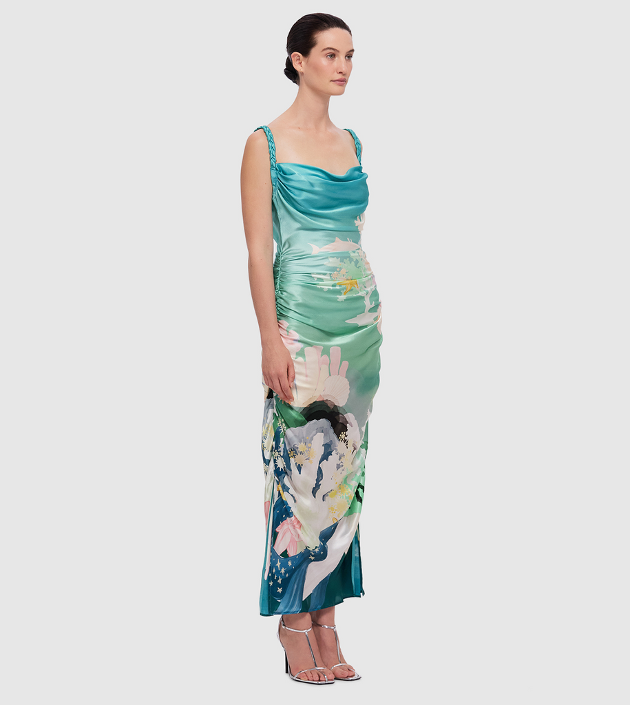 The Rachel Slip Dress is made from 100% premium silk in the LEO LIN exclusive Neptune Print in Seagrass. The bias cut dress features braided straps, a soft cowl neckline, a ruched bodice and side skirt splits. By Leo Lin, now available at After Eight. 