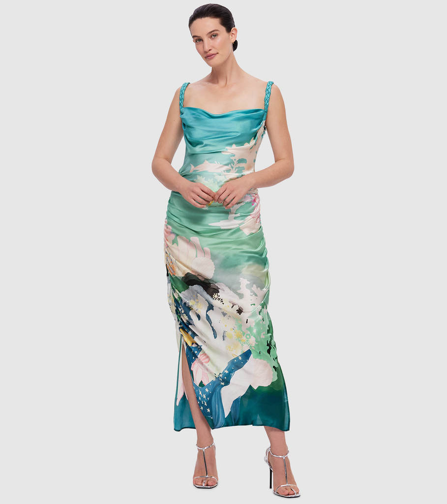 The Rachel Slip Dress is made from 100% premium silk in the LEO LIN exclusive Neptune Print in Seagrass. The bias cut dress features braided straps, a soft cowl neckline, a ruched bodice and side skirt splits. By Leo Lin, now available at After Eight. 