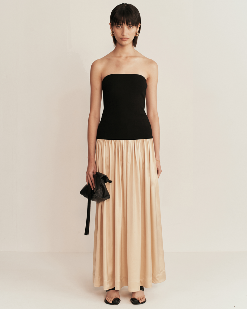 ESSE Studio's Lumber Strapless Dress epitomizes timeless elegance and minimalist charm, showcasing a refined sensuality. With a strapless design and waist-hugging bodice, it accentuates feminine sophistication. By Esse, now available After Eight. 