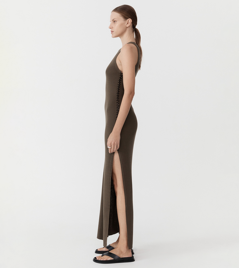 A minimalist staple with a difference. The Stitch Detail Dress features a 100% organic cotton ribbed construction, fitted silhouette, maxi length, and lace-up stitch side detail ending in statement-making side slits. Pair the Stitch Detail Dress with your favourite minimalist sandals for a refined, timeless ensemble. By St Agni, now available at After Eight. 