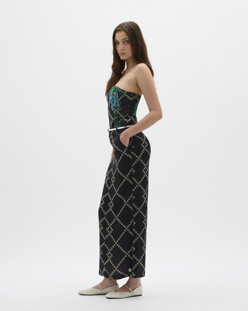 Created in a lustrous, silky blend with a Muma signature logo designs, the skirt is a specialty piece pairing with the Jade Vine Bandeau. Expertly crafted in vegan cupro, this structured skirt buttons at the front and splits at the back, flowing down an elongated hemline to the ankles, meeting embroidered logo detailing. Simultaneously elegant and relaxed, the style allows for movement, festivity, and indulgence all around. By Muma World, now available at After Eight. 