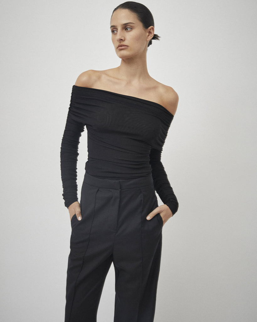 The mesh glove top in black is crafted from a double layer of mesh knit and features off the shoulder neckline and ruched sleeve detail with thumb hole. By Beare Park, now available at After Eight. 