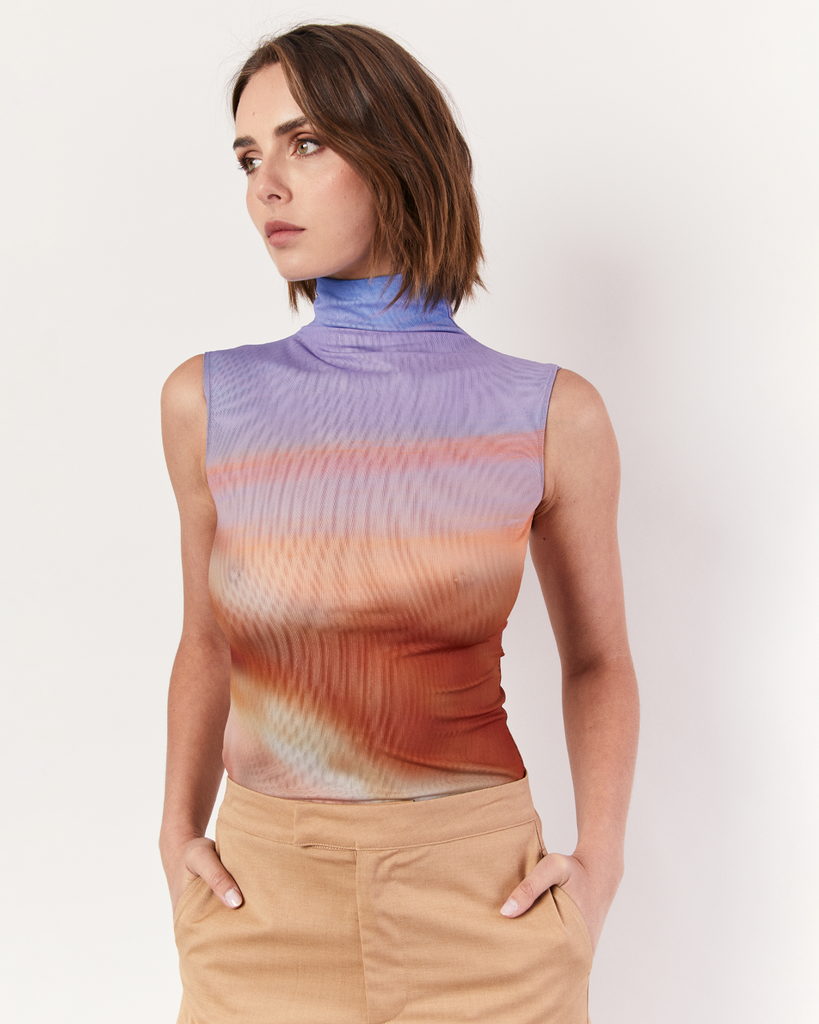 Introducing the exclusive Funnelneck Tank in the breathtaking Romy Sunset Vista print. Embrace the beauty of the horizon with this captivating design. Crafted from lightweight mesh, this tank offers both style and breathability, making it perfect for warm days or layered looks. By Romy, now available at After Eight. 