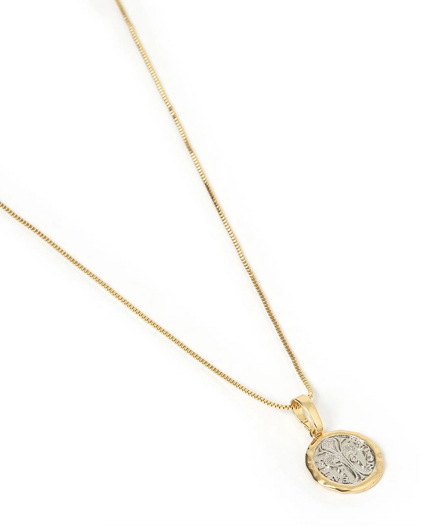 With a classically vintage coin charm, the Piccolo Necklace is great for mixing metals! With a two tone look, this piece will stack with any gold or silver chains. By Arms of Eve, now available at After Eight. 