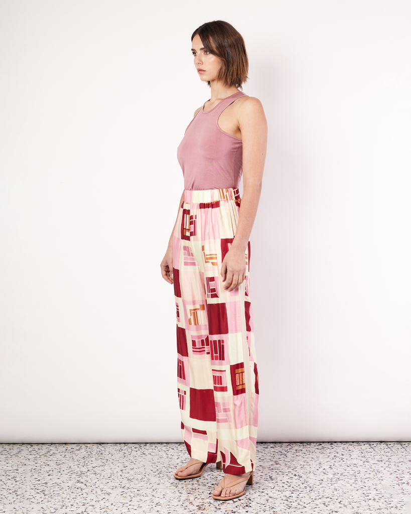 The Retro Pant is a relaxed straight leg pant featuring an elastic waistband and side pockets. It is crafted from a silky recycled Oeko-Tex® certified viscose in the Resort 24' retro-inspired print. By Romy, now available at After Eight. 