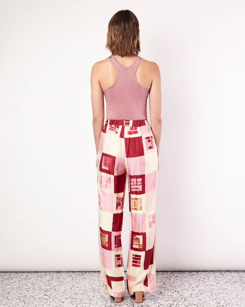 The Retro Pant is a relaxed straight leg pant featuring an elastic waistband and side pockets. It is crafted from a silky recycled Oeko-Tex® certified viscose in the Resort 24' retro-inspired print. By Romy, now available at After Eight. 