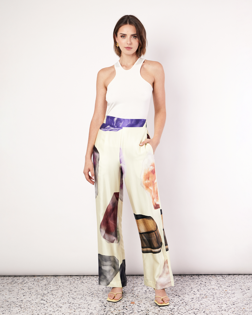 The Gemstone Pant features an updated waistband design that includes a flat band at the front and elastic at the back to flatter the figure. It features side pockets in our signature relaxed straight-leg pant silhouette, offering an elevated yet comfortable style. It is crafted from a silky recycled Oeko-Tex® certified viscose in the Gemstone Print, designed exclusively for Romy. By Romy, now available at After Eight. 