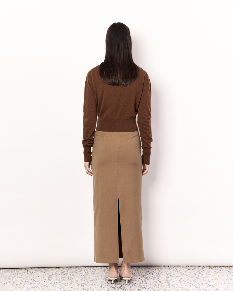 The Cropped Collared Sweater is a trans-seasonal knitwear essential, featuring a collar, deep-v neckline, and cropped hem. It is crafted from a luxurious Wool Cashmere blend in an Olive Brown hue. By Romy, now available at After Eight. 