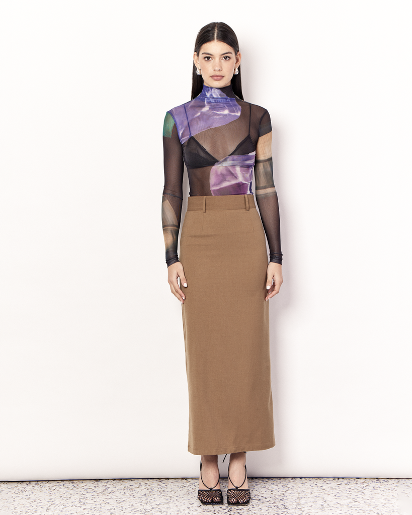 The Maxi Suiting Skirt is a tailored skirt to take you from desk to dinner with ease, featuring belt loops and a back split for ease of wear. It is crafted from a soft wool blend in Tan. By Romy, now available at After Eight. 