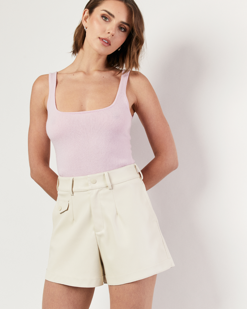 The Vegan Leather Short in cream reimagines a Romy signature fabrication in a contemporary silhouette and refined proportions. Crafted from soft vegan leather and perfectly tailored to a high-thigh length. Style with the coordinating Vegan Leather Cropped Shirt. By Romy, now available at After Eight. 