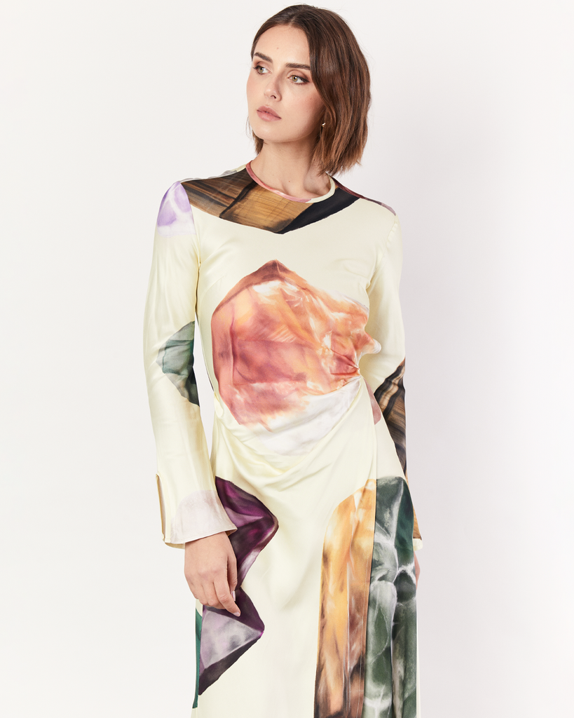 The Gemstone Wrap Dress boasts a fluid form and elevated style, featuring gathered detailing and a leg split. It is crafted from a silky recycled Oeko-Tex® certified viscose in the Gemstone Print, designed exclusively for Romy. By Romy, now available at After Eight. 