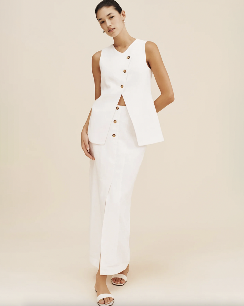 Classic and chic, the Gigi Gilet is a must-have piece for your staple wardrobe. Cut from certified linen, it features an elegant high neckline and statement front split. Style yours as a set with the coordinating Gigi Column Skirt. The crisp white hue makes it perfect for daytime events or a memorable bridal moment. By Posse, now available at After Eight. 