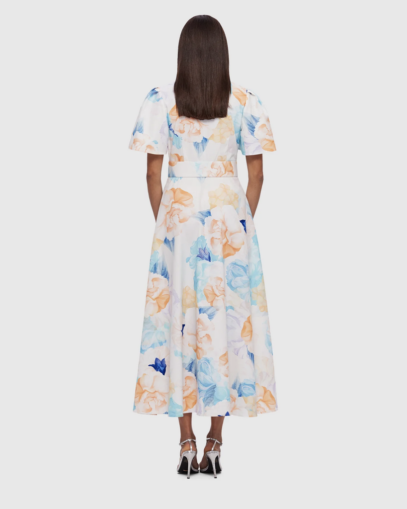 The Bianca Short Sleeve Midi Dress in Rosebud Print from LEO LIN radiates grace and timeless charm. Featuring a Mandarin collar, concealed button tab, and flared sleeves, it's a dress of understated sophistication. The fitted waistline and pleated A-line skirt craft a classic silhouette, while the matching belt adds a touch of personal flair. Ideal for special occasions, this dress seamlessly blends elegance with individual style. By Leo Lin, now available at After Eight. 