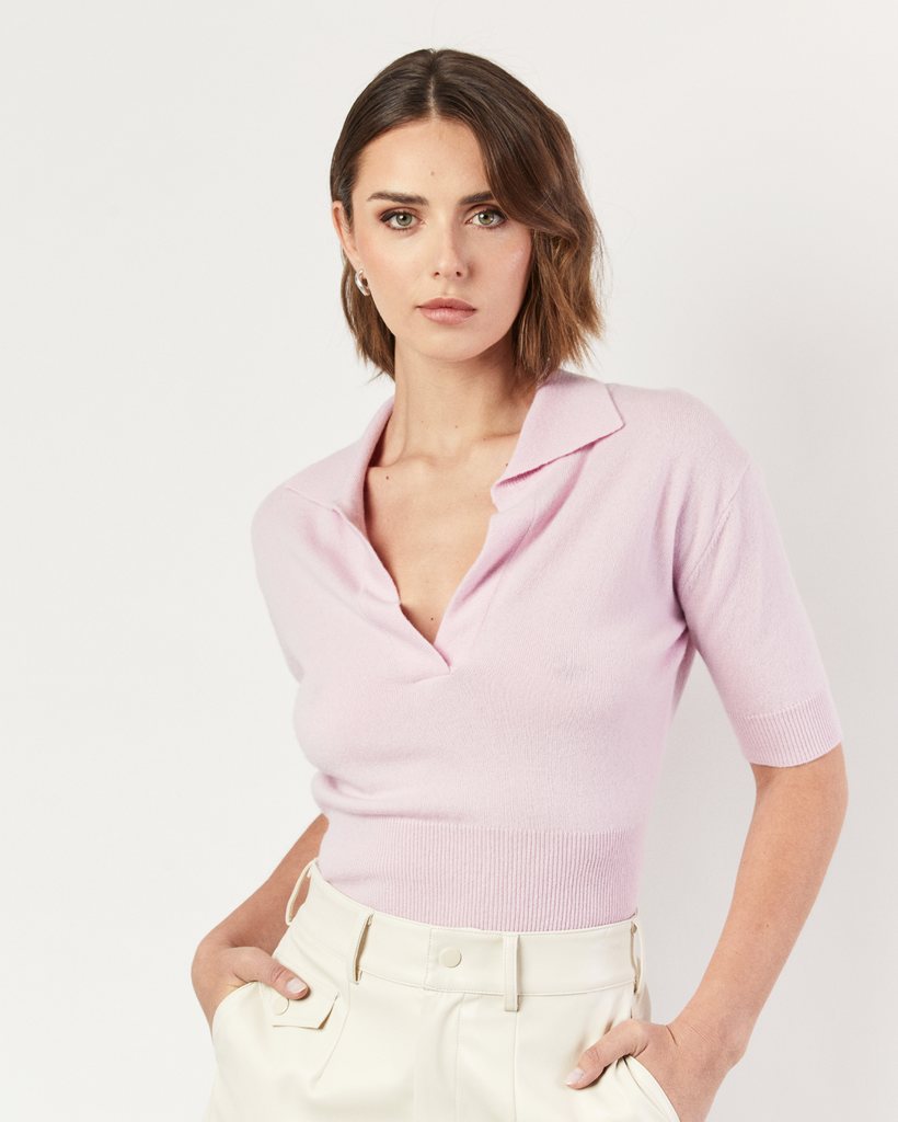 The Collared Short Sleeve Sweater is an interpretation of Romy's signature knitwear silhouettes. Sumptuous and soft, the pink Cashmere blend sweater is crafted with a v-neck collar and flattering a cropped hem. By Romy, now available at After Eight. 