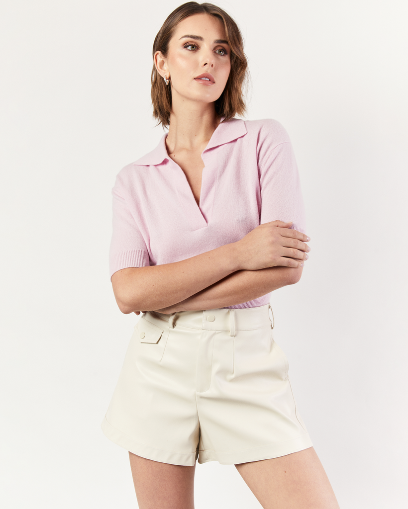 The Collared Short Sleeve Sweater is an interpretation of Romy's signature knitwear silhouettes. Sumptuous and soft, the pink Cashmere blend sweater is crafted with a v-neck collar and flattering a cropped hem. By Romy, now available at After Eight. 
