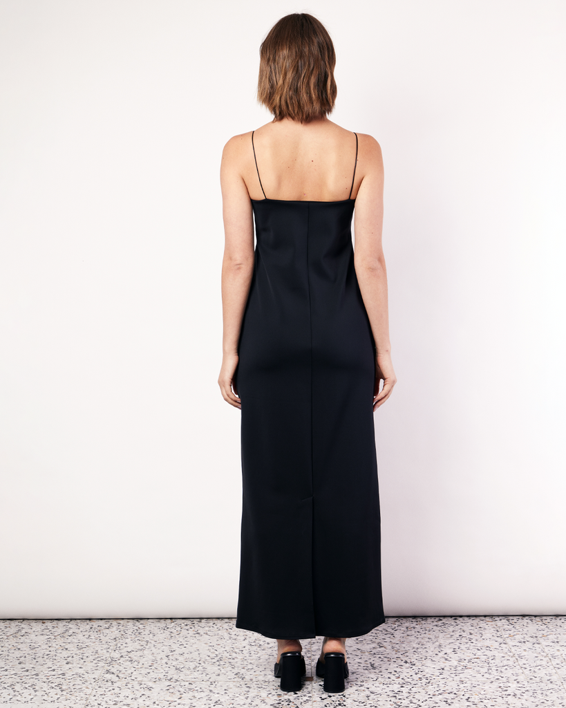 This floor-length bandeau dress is crafted from a luxurious stretch scuba fabrication, featuring rouleau shoulder straps and an inner shelf bra. With side pockets and a classic and elegant silhouette, this will soon become your go-to black dress. By Romy, now available at After Eight. 