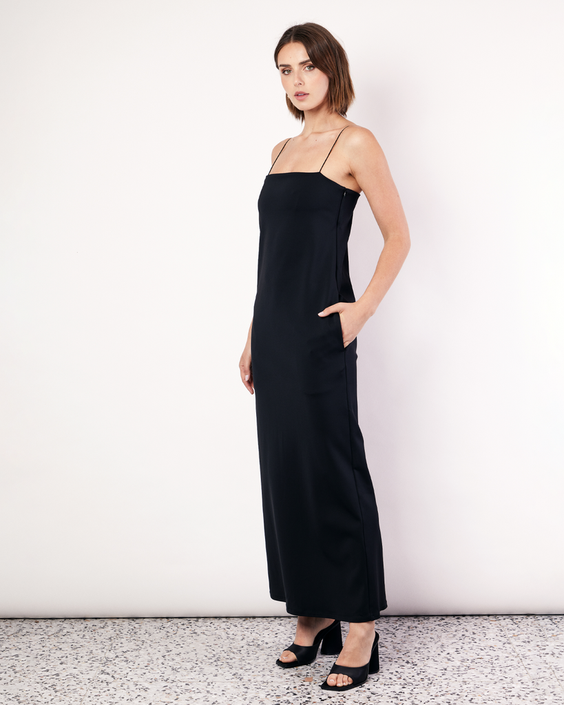 This floor-length bandeau dress is crafted from a luxurious stretch scuba fabrication, featuring rouleau shoulder straps and an inner shelf bra. With side pockets and a classic and elegant silhouette, this will soon become your go-to black dress. By Romy, now available at After Eight. 
