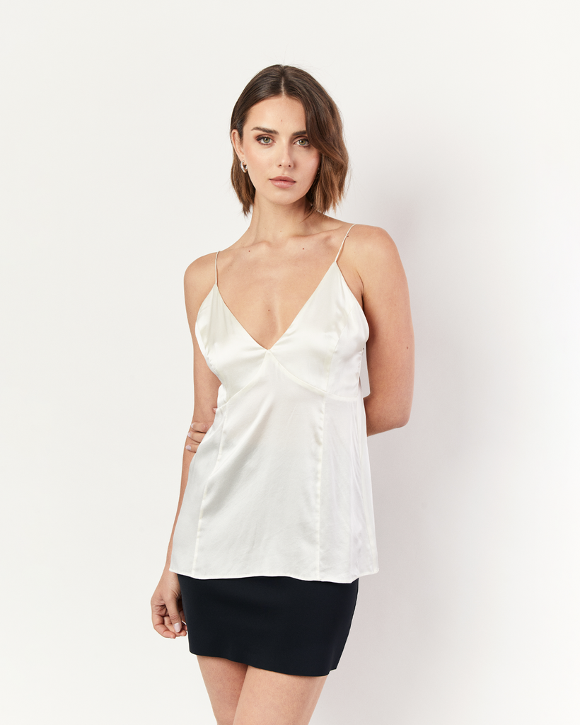Our Deep V Cami is a sexy camisole style top that is crafted from fluid silk in cream. Featuring a plunging v-neckline refined by single darts at the bust and suspended from rouleau straps. Its delicate finishings include a keyhole back that fastens with a covered button. By Romy, now available at After Eight. 