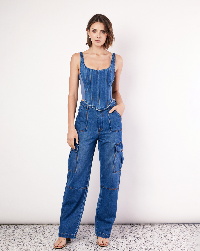 The Denim Cargo Pants are your go-to everyday denim jeans, featuring a relaxed straight leg with cargo pockets and unique front seam detailing. By Romy, now available at After Eight. 