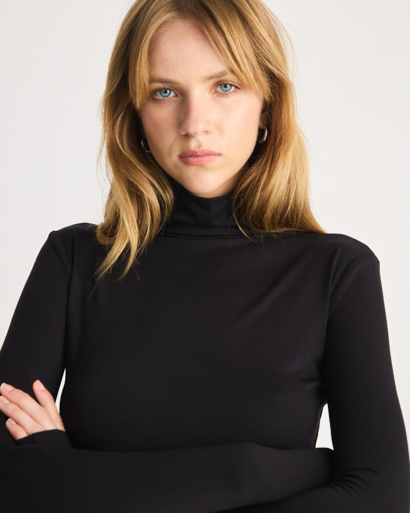 The Stretch Funnel neck is a wardrobe staple to be worn on all occasions, designed to fit close to the body. It is crafted from soft Oeko-Tex® Certified Bamboo Jersey in Black. By Romy, now available at After Eight. 