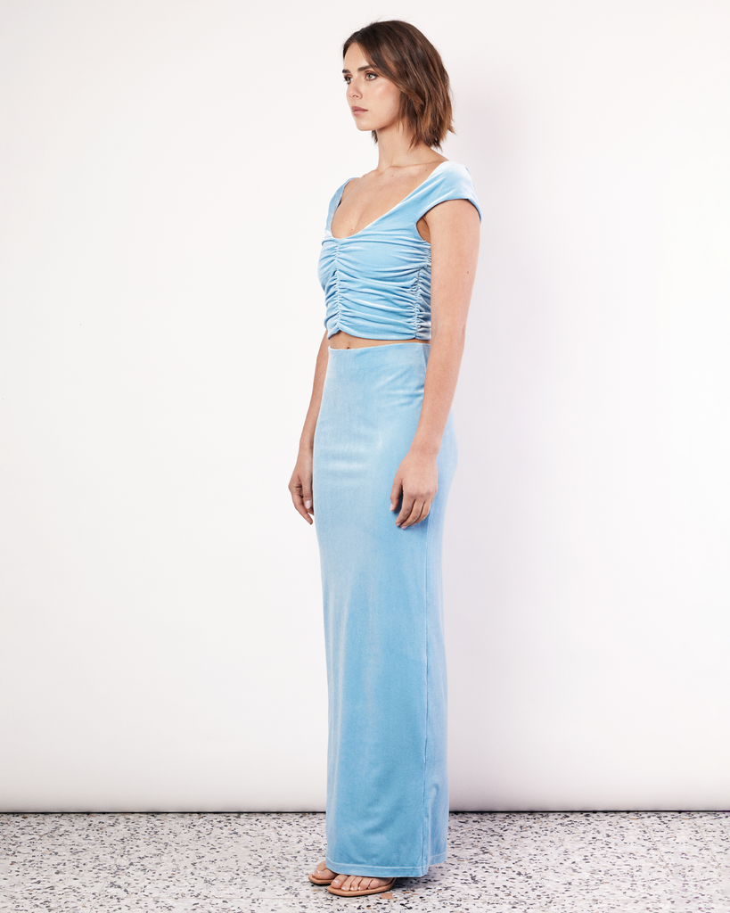 The Velvet Maxi Skirt is a figure hugging silhouette that falls to an elegant maxi length. It has an elastic waistband and is crafted from a plush stretch Velvet fabrication in a light Blue hue. By Romy, now available at After Eight. 