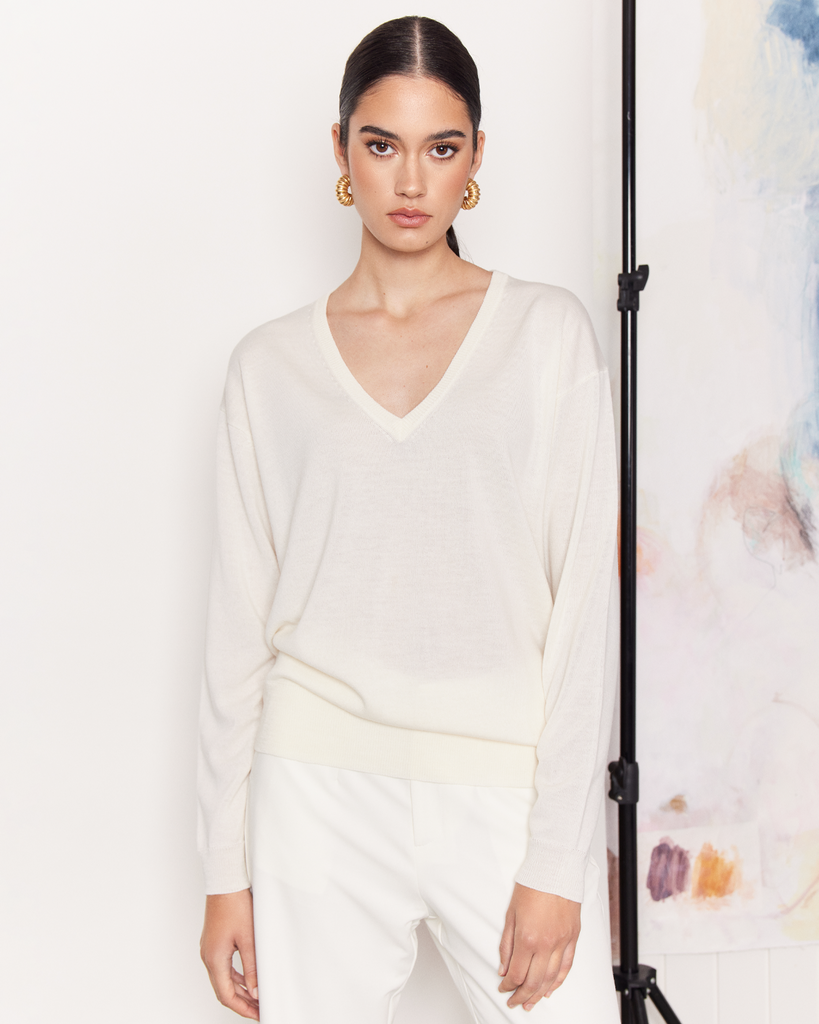 The Deep V Sweater is a trans-seasonal wardrobe staple cut from a lightweight 100% Extra Fine Merino wool in a cream colour-way. An easy-wearing layer to throw over any outfit. Pair with your favourite jeans for everyday wear or white trousers for an understated evening look. By Romy, now available at After Eight.  