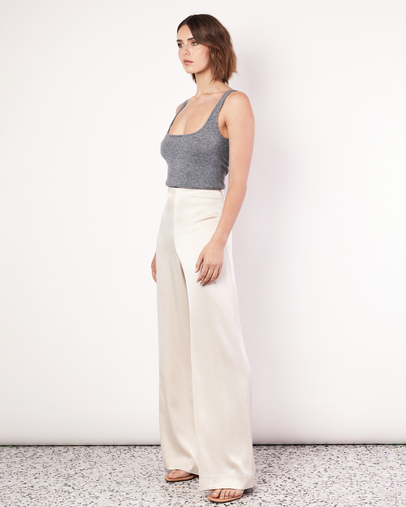 The Fluid Satin Pants are a Romy staple, recut for Resort in a buttery cream colourway. They are a high waisted style, loose fitting through the leg and feature a side invisible zip, and an elastic detail through the waistband making them comfortable to wear all day long. By Romy, now available at After Eight. 