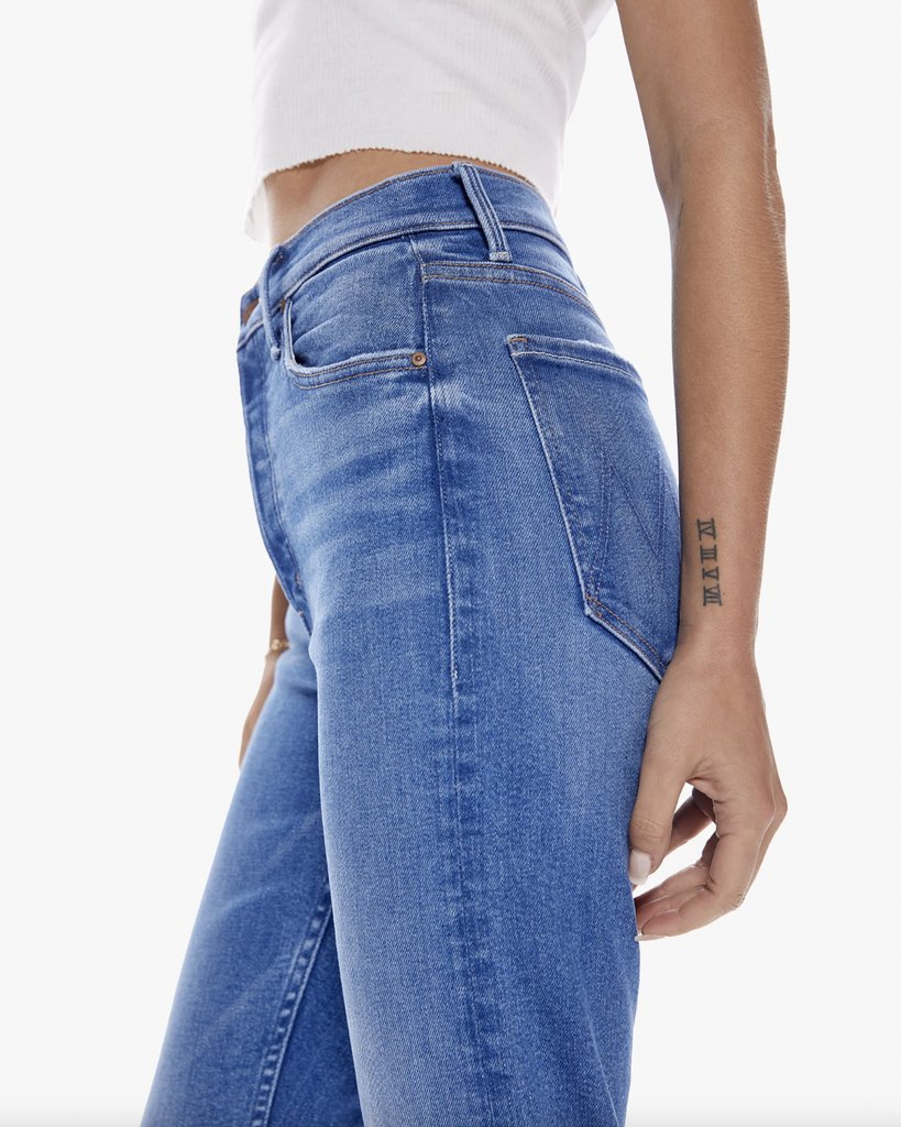 The Mother bestselling high-rise straight leg with a button fly and a cropped inseam. Made from denim with a touch of stretch, Layover is a bright mid-blue wash with whiskering and fading throughout. By Mother Denim, now available at After Eight. 