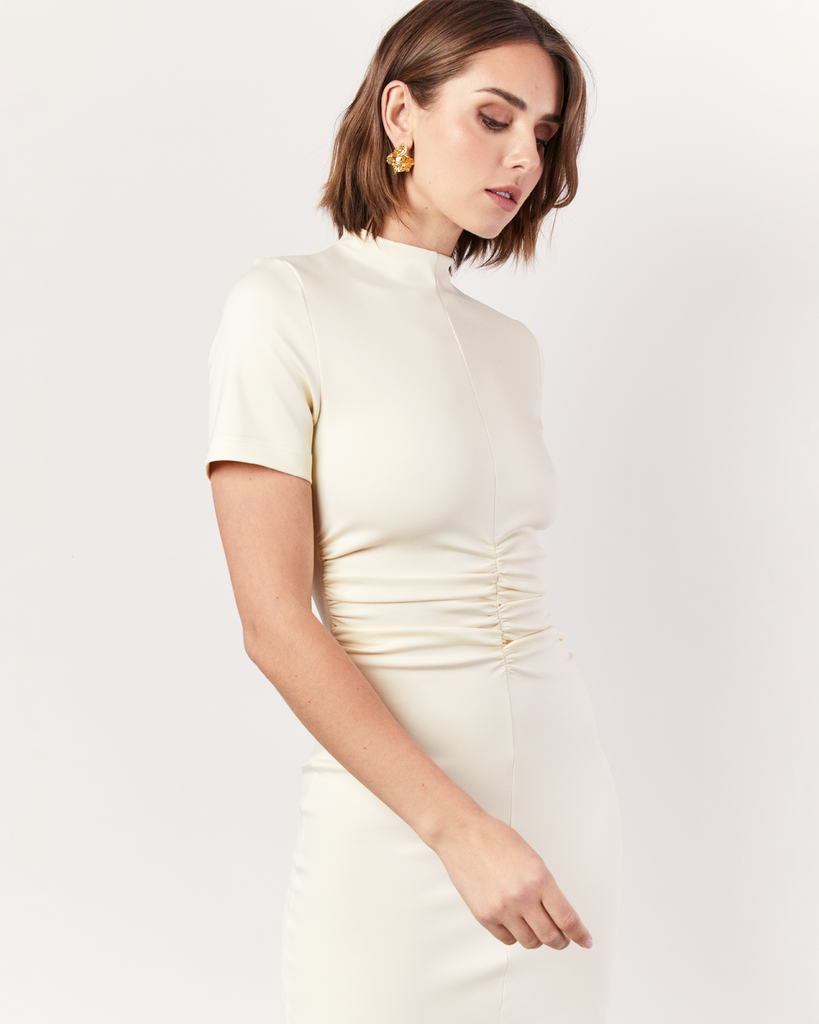 This stunning dress features a gathered front detail that adds an intriguing twist to the classic silhouette. Crafted from luxurious stretch scuba fabric, it offers a sleek and structured look that effortlessly flatters your figure and hugs you in. By Romy, now available at After Eight. 