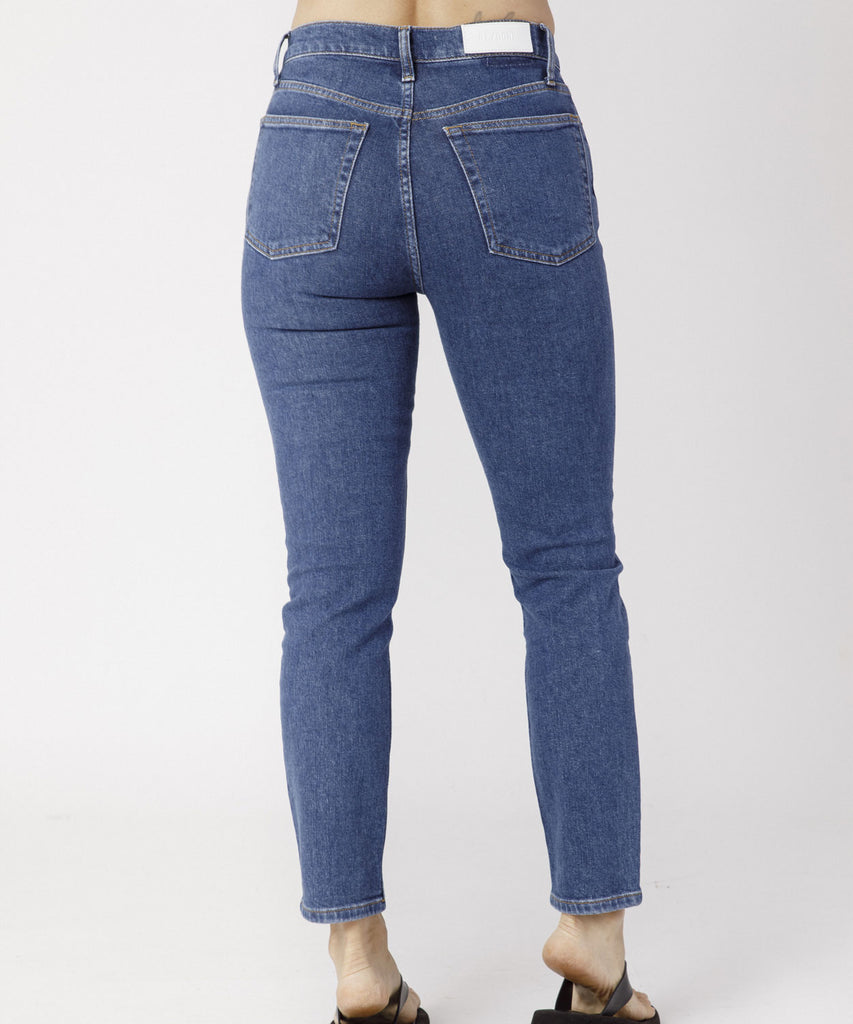 The 90s High Rise Ankle Crop Jeans are made from comfort stretch denim are a slim fitting skinny leg style with a raw hem and button fly available in a Dark Blue Wash. Made by sustainable Los Angeles brand Re/Done, available at After Eight.