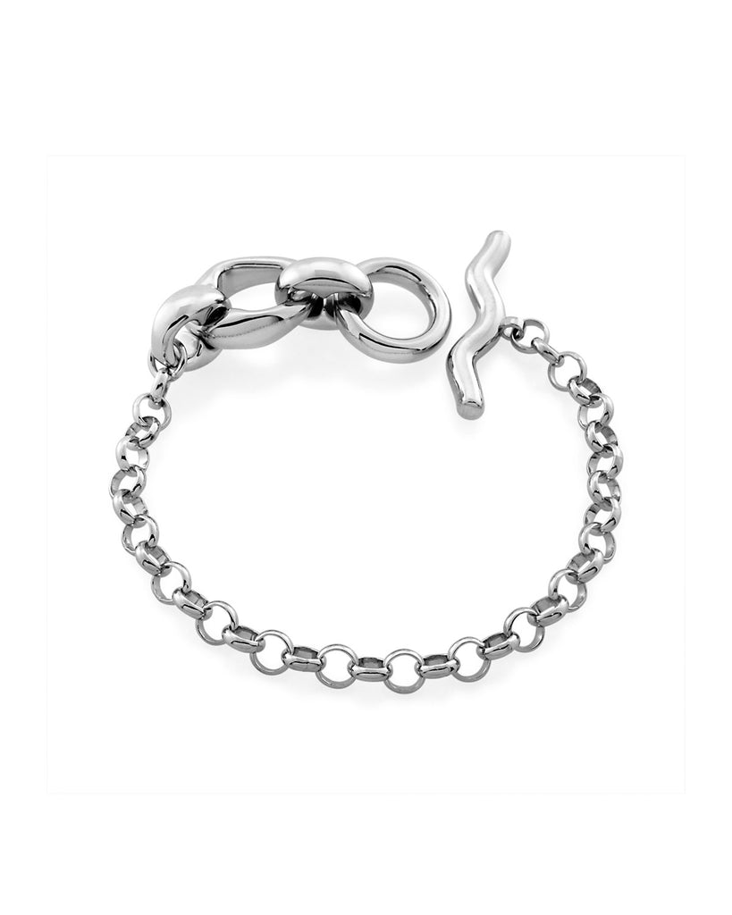 The Mother Jug Fob bracelet is a silky rolo chain attached to a fluid, wave like t-bar and Mineraleir's signature mother jug chain links, made from recycled sterling silver plated with Rhodium. By sustainable Australian brand Mineraleir.